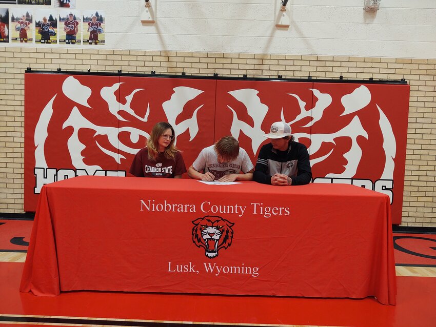 NCHS senior David West signs his Letter of Intent for track and field at Chadron State College as his family watches.