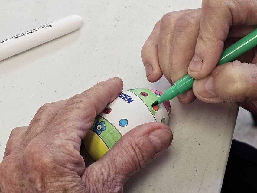 Creative hands decorate an Easter egg at the Services for Seniors Activity Center.