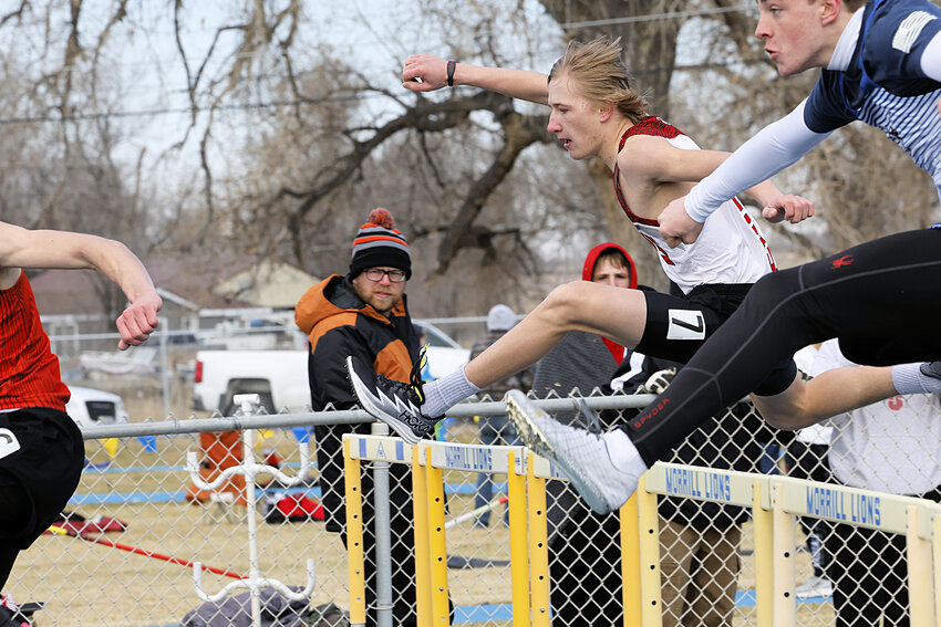 Sophomore Isaac Assman, center, clears a hurdle in the 110-meter prelims at Morrill Early Bird Meet on March 23. Assman placed 10th in the prelims, posting a time of 18.47 seconds.