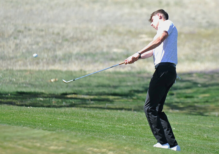 EWC freshman Joshua Chapman hits the ball onto the putting green during the first round of the home tournament at Cottonwood Country Club on April 12. Chapman tied for second place at the tournament.