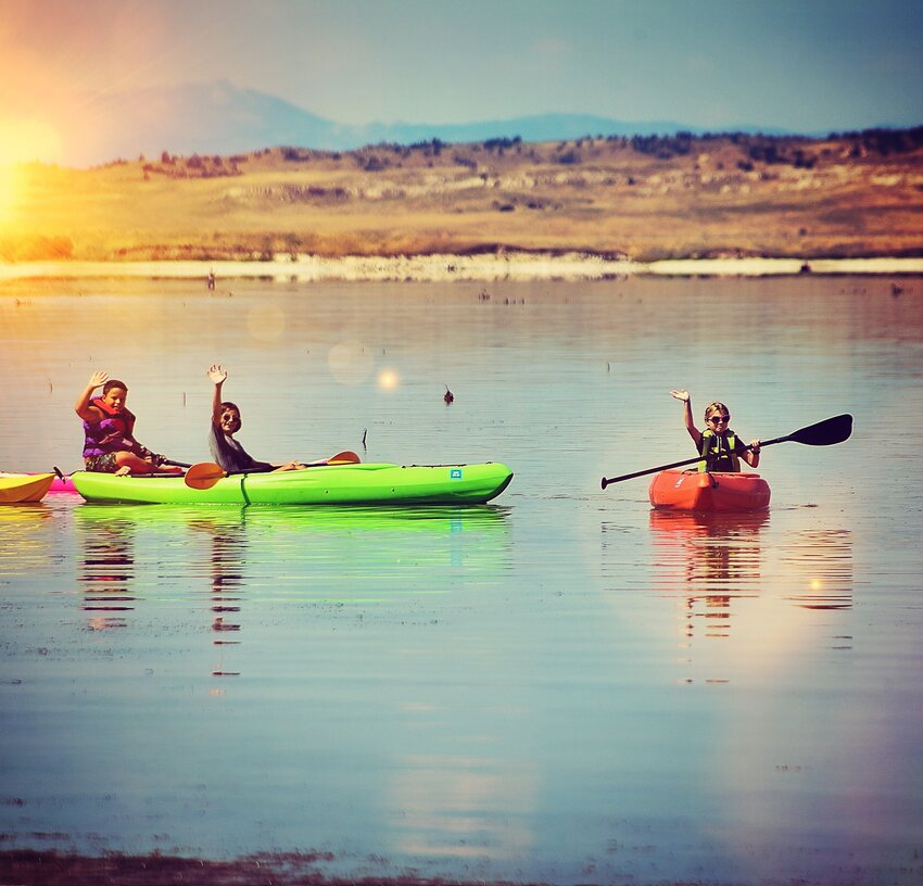 Youth paddle colorful kayaks on Gray Rocks Reservoir, east of Wheatland.
