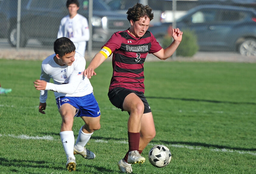 Senior Adam Bartlett maneuvers the ball away from his opponent during the April 26 game.
