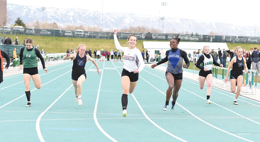 Sophomore Brooklyn Asmus, center, smiles as she crosses the finish line ahead of the competition in the 100-meters at the Wyoming Track and Field Classic in Casper on April 26. Asmus bagged gold in the 100-meters and snagged second in the 200-meters.