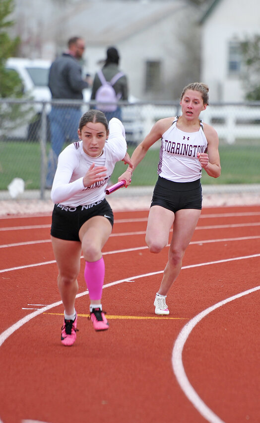 Junior Jaycee Hurley, left, shifts into high gear as sophomore Natalie Hawes approaches for the handoff in the 4x100-meter relay  in Torrington on Friday. The team garnered gold in the event.