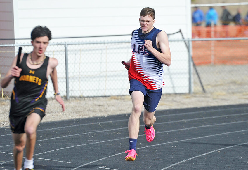 Sophomore Brady Cook, right, catches up to his opponent in the 4x400-relay in Bayard in April.  Cook helped his teammates win both the 4x100- and 1600-sprint medley relays at the SEWAC championships on May 4.