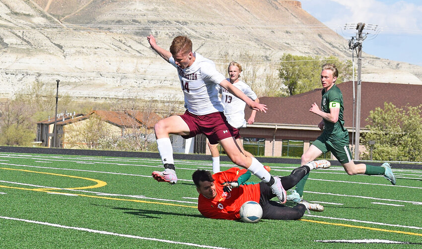Junior Skyler Thomas catches air as he attacks Green River’s offense in the third-place game on May 18. Also pictured, in back, is junior Elijah Hatch.