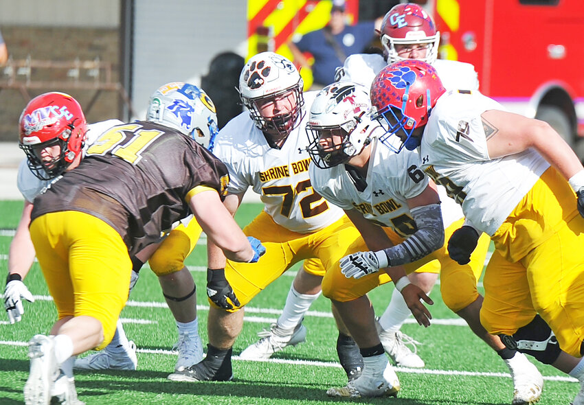 THS graduates Trey Parriott, No. 72, and Brayden Frazier, No. 64 (second from right) prepare to block  for the South Team’s offense against their North Team opponents during the 51st annual Shrine Bowl at Natrona County High School on June 8.