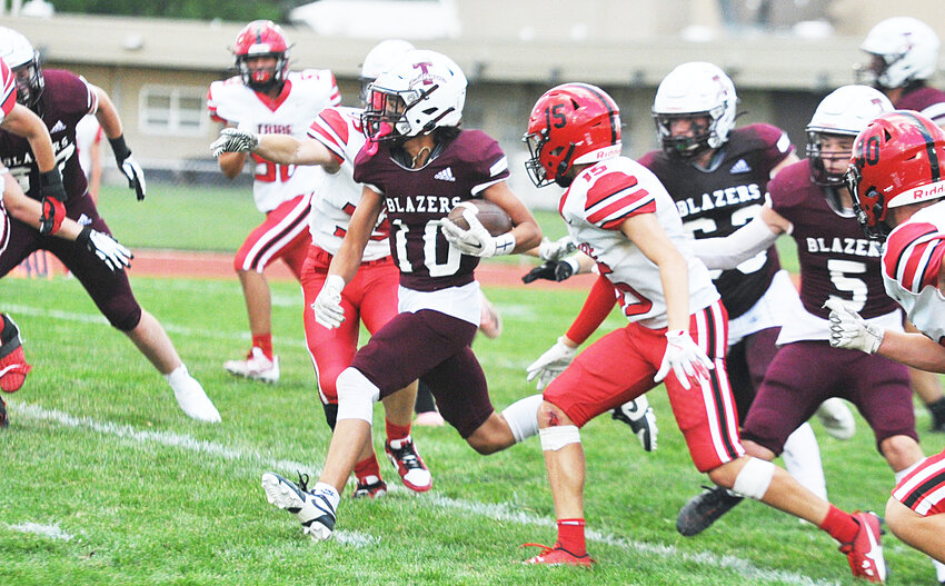 Junior Landre Greiman, No. 10, dashes for the end zone to score a touchdown for the Blazers against Cheyenne Central’s junior varsity squad on September 13. Also pictured are senior Jeramiah Haffner, center, and junior Colby Sandusky, right.