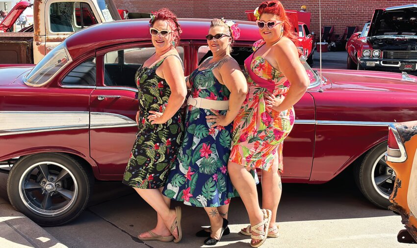 The “pinup girls” - “Trixie Von Torque”, “Lena Wylde” and “RuBee Rambler” pose in front of the cars they brought to the car show.