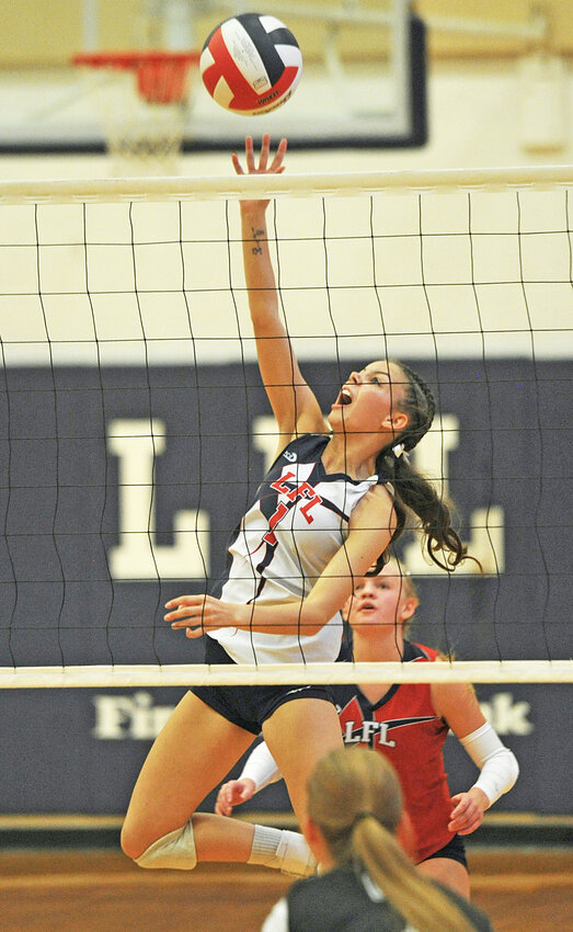 Senior Addison Scott slams over a kill against Guernsey during the September 20 Homecoming Week victory.  Also pictured is senior Kenzi Wiklins in back.