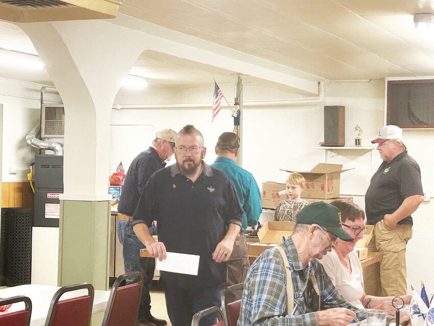 Member Jeff Thomas carries one of 10 gift certificates to a winner at The Friends of Guernsey Lodge Raffle held at the Guernsey VFW Post September 14th. Also shown are: Bob (sitting, l-r) and Sharon Holloway; Disco Harris (standing in the background, l-r), Charlie Walker, Wyatt  and Shane Clevenger.