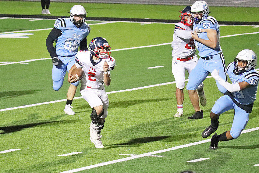 Junior Colt Brown, No. 2, drives the ball forward for the Doggers against Cheyenne East’s junior varsity squad on October 3 as senior Ned Nelson, right, makes a block.