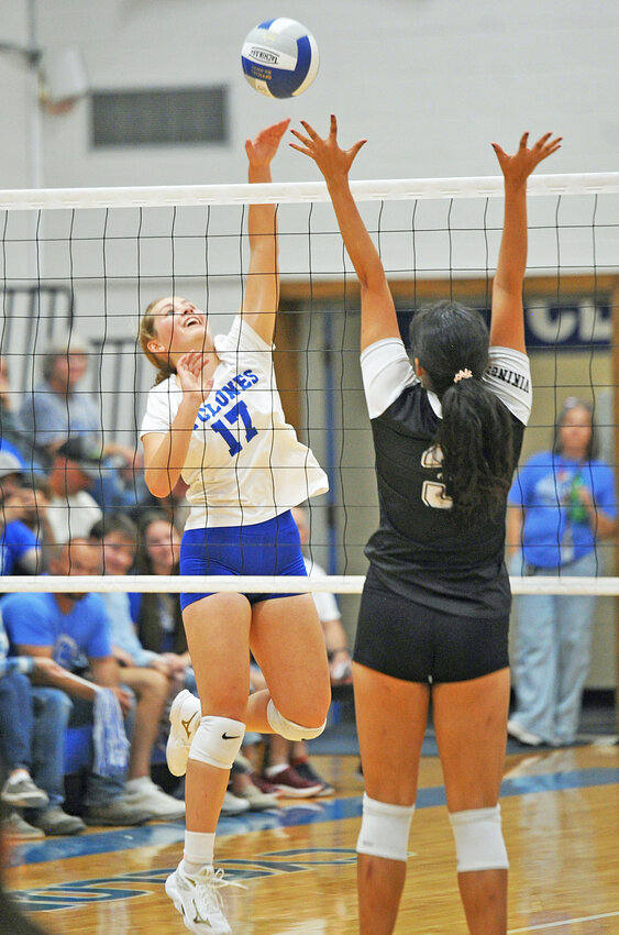 Senior Anna Hartman, left, goes up for a kill against Guernsey during the Homecoming game on October 5.