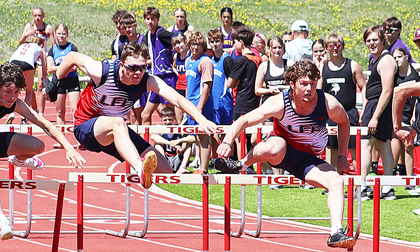 Senior Louden Bremer, right, and junior Brady Cook, left, race for the finish line in the 110-meter hurdles at the SEWAC meet in Lusk on Saturday, May 10. Bremer went on to win the 110-hurdles and clinch gold in two individual events and two relays. Cook came in second place in the 110-meters.