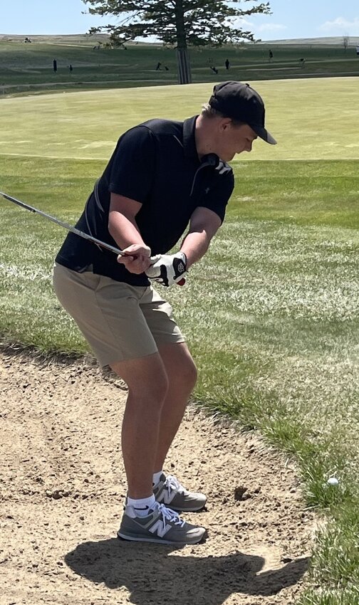 Ridge Kupke chips from short of the green on the 1st hole at Hay Creek Golf Club.   