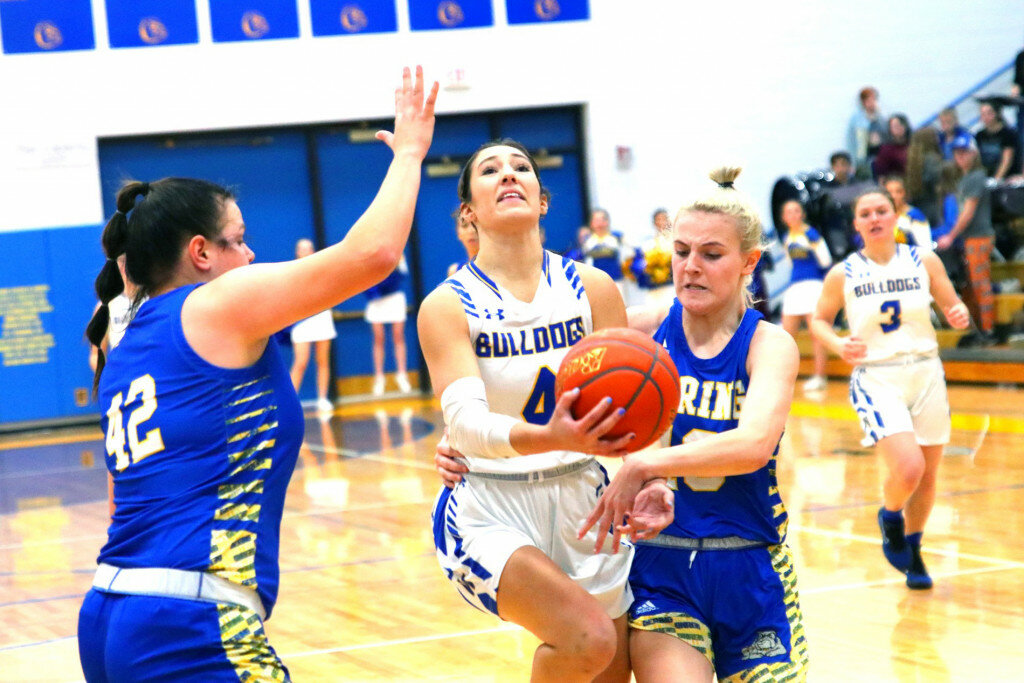 W1: Wheatland High School senior Brinley Heimsoth splits the Gering defense in a game played last Thursday night in Wheatland. Heimsoth was the leading scorer, hitting five three-point shots for 15 points.
W2: The Wheatland girls played Cheyenne south for the second time in one week and came out on top with a 59-31 victory. Senior Grace Battershell is seen driving through heavy traffic against a Lady Bison defender.