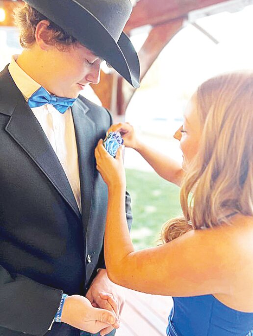 “Careful with that pin!”  Layla Noggle pins a corsage on Mason Collar’s coat before heading to the Guernsey-Sunrise prom.