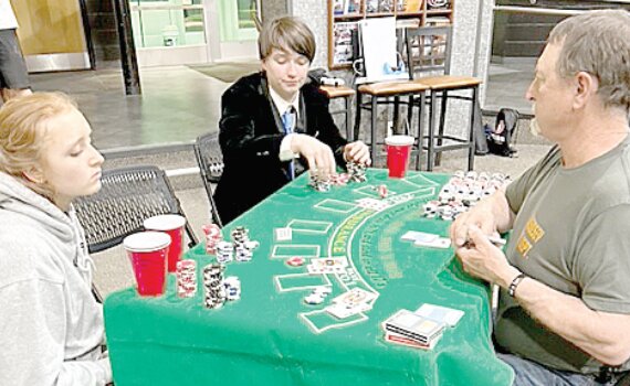 Blackjack dealer Max Garner waits as Jordan Atwood and Emmett Dawson contemplate their next move at the Blackjack table. Hundreds of dollars in merchandise and gift certificates were donated by local businesses and individuals as prizes for the casino games played during the after-prom party.