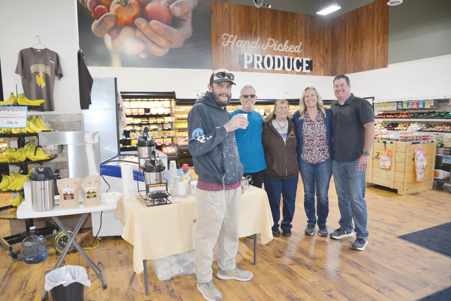 John Lister (left) tries the locally-made coffee served as samples at the newly-opened grocery store in Guernsey. The coffee roasters from Cheyenne Coffee Company in Wheatland, Bill and Kris Born (center), were happy to share samples and add their product to the new store, Superfoods, owned by Jodie and BJ Axford (right).