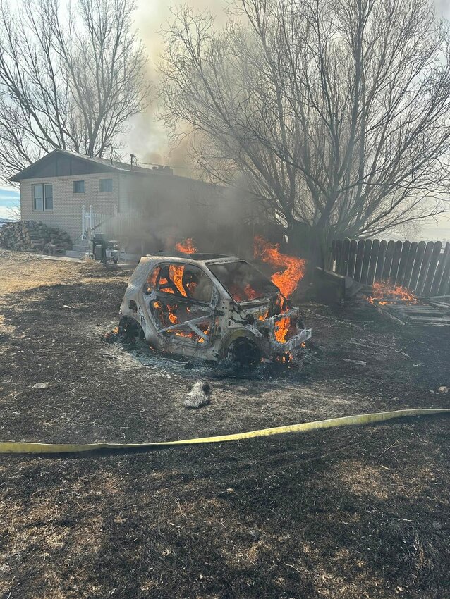 A Smart car is engulfed in flames after it caught fire last week at a Bridger Valley residence. A resident was conducting a barrel burn but left it unattended. The family inside the home heard a small explosion before noticing the fire had spread from the barrels to the grass.