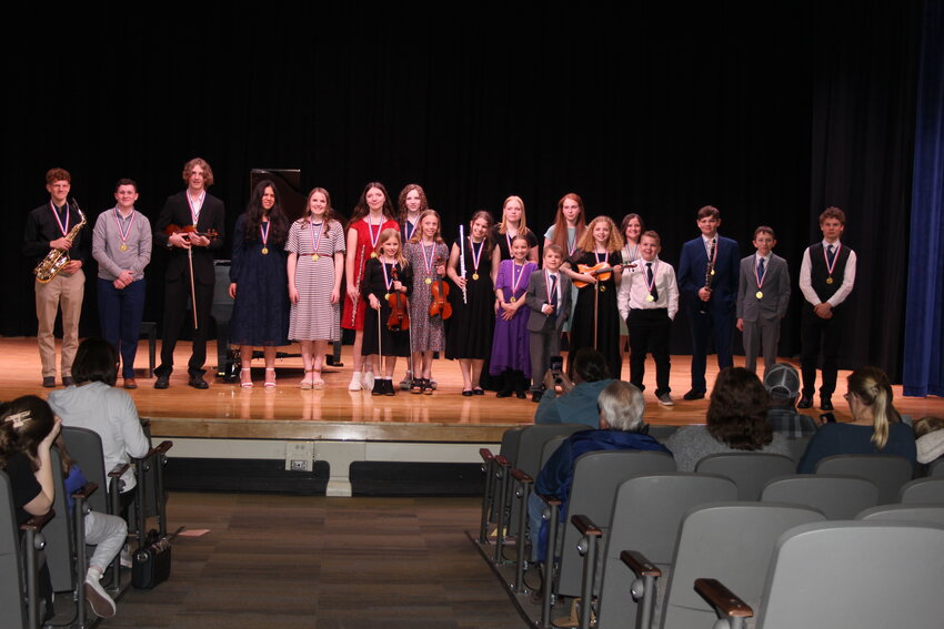 Nineteen young musicians line up for a curtain call at the end of their individual presentations during the concert to celebrate the end of the Young Musicians Festival, which was held on Saturday, March 29, at Evanston Middle School. The festival is sponsored by The Arts Inc. and began at 8 a.m., with workshops going throughout the day. About 170 young people from around the region, including some from Utah and Idaho, registered to attend workshops, play their instruments and be judged by professional musicians to earn ribbons and cash prizes.