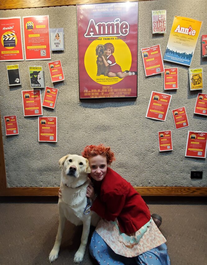 Elizabeth Wagstaff stars as Annie during the musical performance put on by the school’s theater department. Her character is a tough, streetwise kid. The yellow Labrador next to her plays Sandy, orphan Annie’s beloved dog.