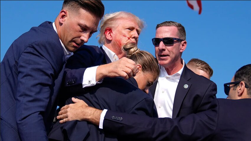 Former President Trump is surrounded by Secret Service agents at a campaign rally on Saturday, July 13, in Butler, Pennsylvania.