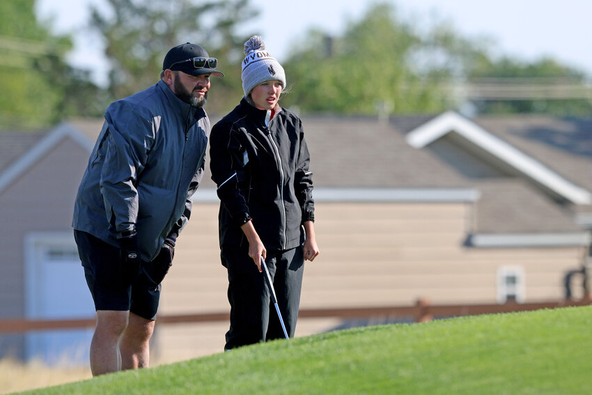 Lady Devils golfer Maddie Brown discusses shot strategy with coach Travis Robinette during Day 1 of the 4A West Conference Qualifier in Casper. The Lady Devils finished runners-up behind Kelly Walsh as a team; Brown, Hailee Ridenour and Marlee Torres were All-Conference.