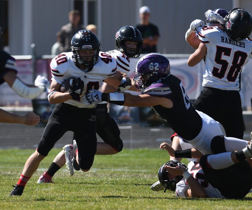 Ranger running back Logan Emery barrels his way past Mountain View’s Seamus Hamilton during Kemmerer’s 49-0 loss to the Buffs Saturday at Mountain View. The Rangers are back in the Bridger Valley Friday to play Lyman. (GAZETTE PHOTO/Don Cogger)