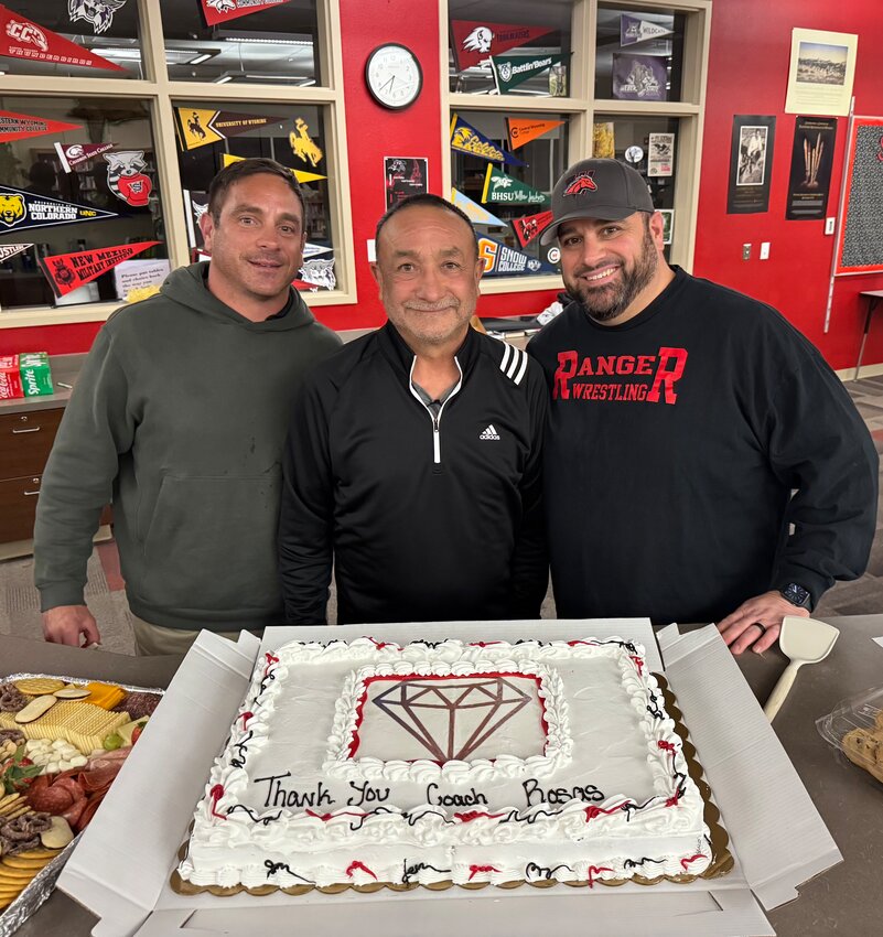 Flanked by sons Michael and Jonathan, coaching legend John Rosas poses with a celebratory cake honoring his years championing Kemmerer and Diamondville wrestling.