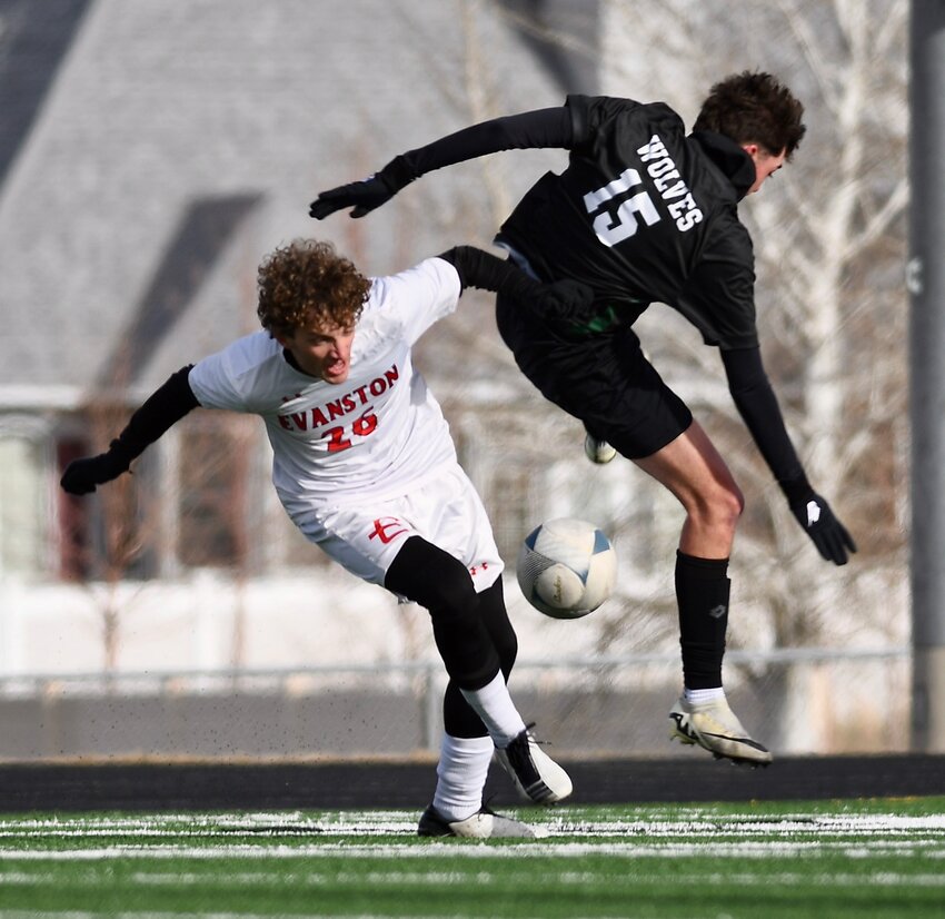 Red Devils defenseman Andrew Dover sends a Green River player airborne as he battles for the ball during Friday’s 8-2 loss to the Wolves. Evanston opened the season 0-2.