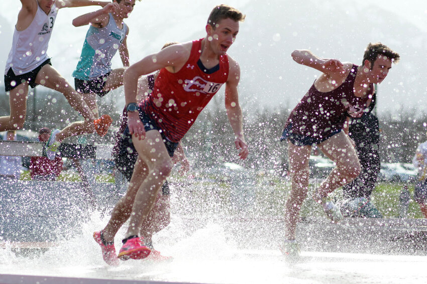 Red Devil senior Paul Baxter splashes down in the frigid water en route to a 7th-place finish in the steeplechase Saturday at the UVU Invitational in Orem, Utah. Baxter also won the 1600 meters, while the Red Devils and Lady Devils both placed third in the team standings.