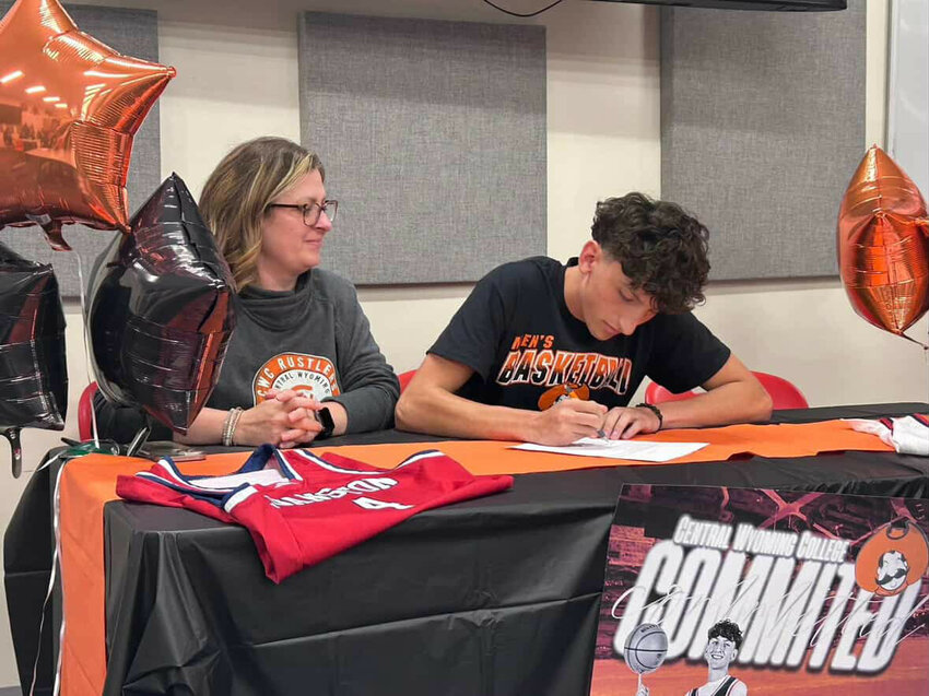Joined by his mom Danielle, Jordan Mendez signs his letter of intent to play hoops next season for Central Wyoming College in Riverton.