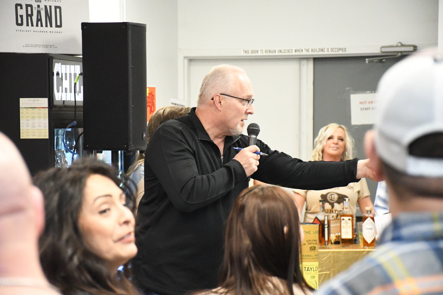Evanston Youth Club board president Kevin Kallas auctions off rare bottles of whiskey during the third annual Bourbon Bash, held at Border Beverage in Evanston on Saturday, Feb. 24. The event drew about 75 attendees and raised nearly $24,000 to help support local youth.