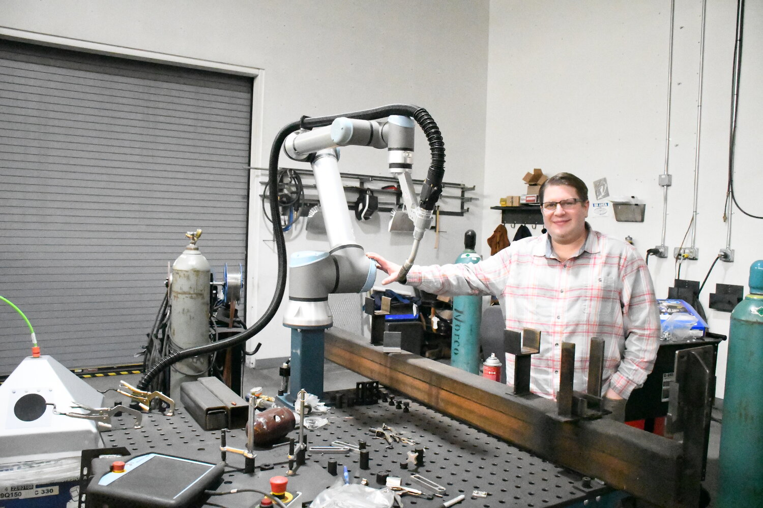 Clean Energy General Manager Sean Columbia poses with his company’s robotic welder.  “We can compete with anyone,” he said, regarding his crew’s stainless steel welding capabilities.