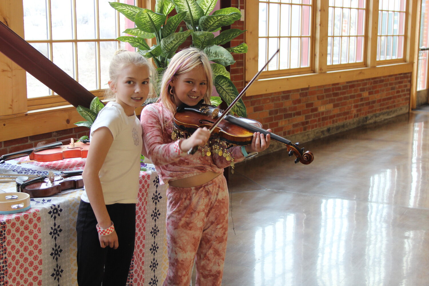 Rylee Shafton-Segura and Vivienne Lash try out the musical instruments at the Music Petting Zoo table in the Roundhouse during the annual Ceili at the Roundhouse Celtic Festival, held March 22-23.