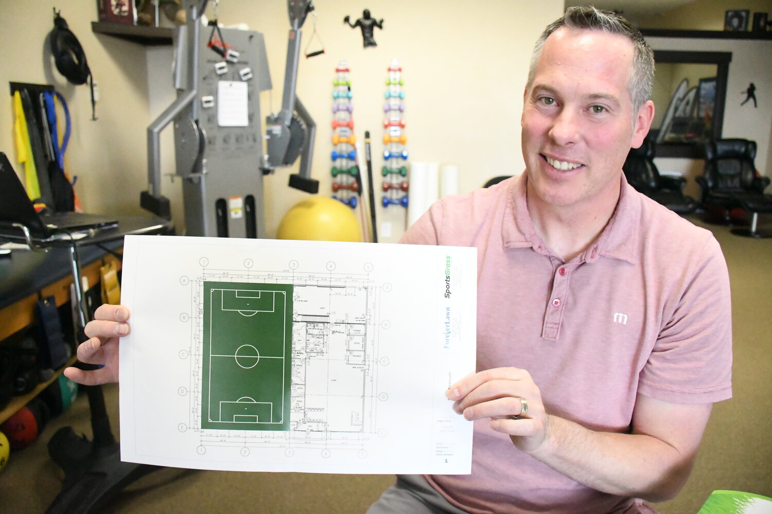 Dr. Justin Dennis of Evanston’s Impact Physical Therapy shows plans for an indoor turf field he’s been working to bring to Evanston. The field would be for community use but would charge a pay-per-use fee.