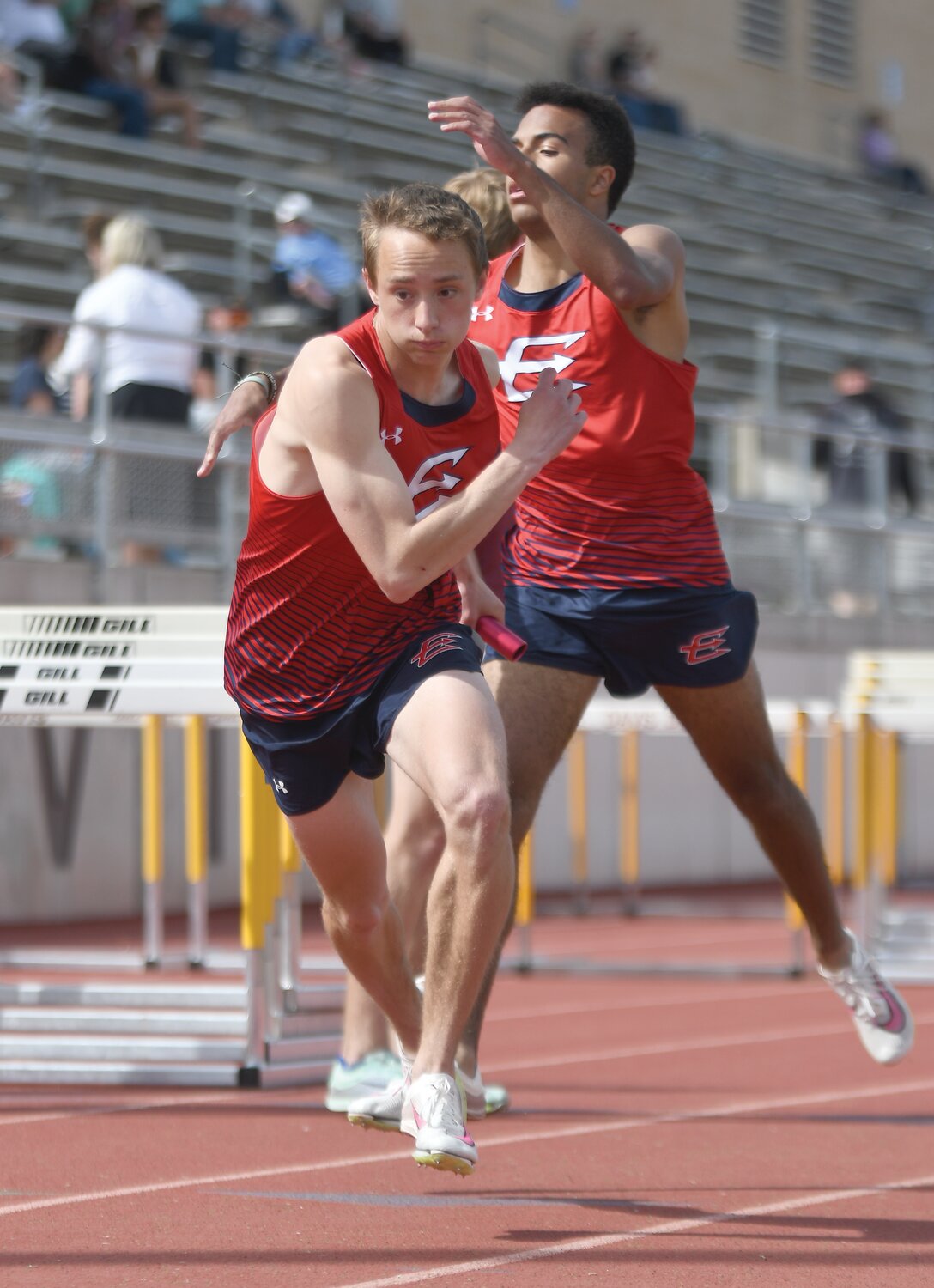 Aidan Conrad (front) takes the handoff from Jamar McDowell during the 4x800 at Saturday’s Davis Invite in Kaysville Utah.