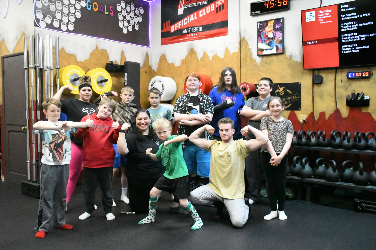 Some members of the 307 Strength Youth Barbell Club pose with their coaches after a training session. Pictured are Jaxxon Williams, coach Ashleigh Clyne, Samuel Manchester, Kole Garfield, coach Maggie Jones, Lincoln Kendrick, Hayes Garfield, Zander Heiner, coach Nate Gilmore, Henry Manchester, Ki Morris and Blare Albrecht.