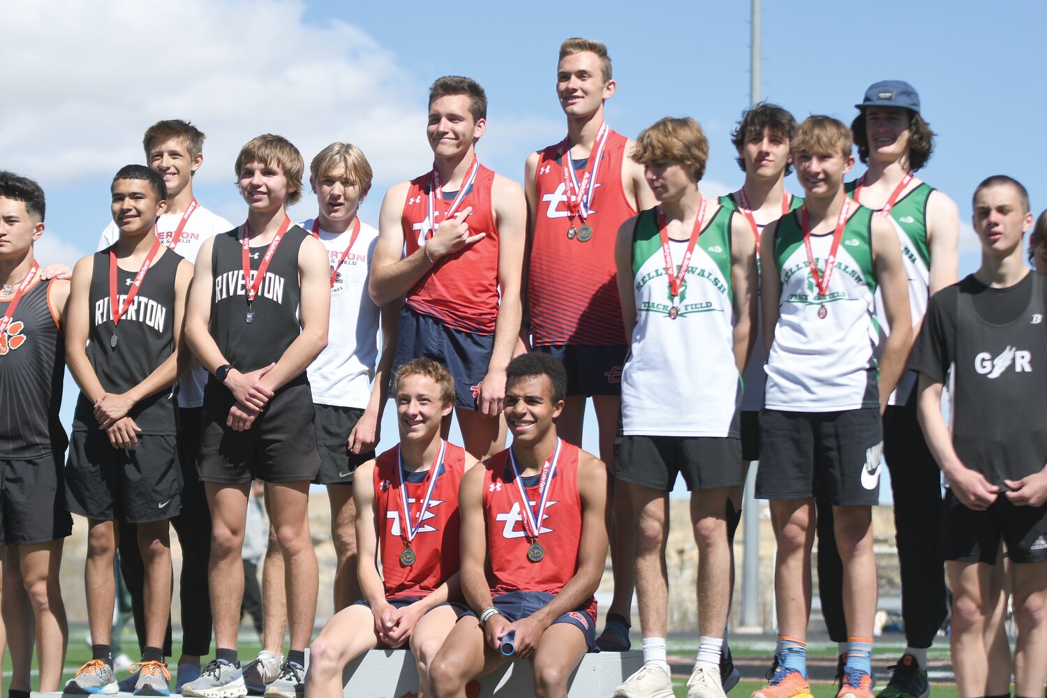 Members of the 4x800 relay team — Gideon Stahl, Paul Baxter (standing), Aidan Conrad and Jamar McDowell (sitting) — are all smiles on the podiium after winning the event in a time of 8:06.56. The time set broke the previous school record of 8:07, set in 1984.