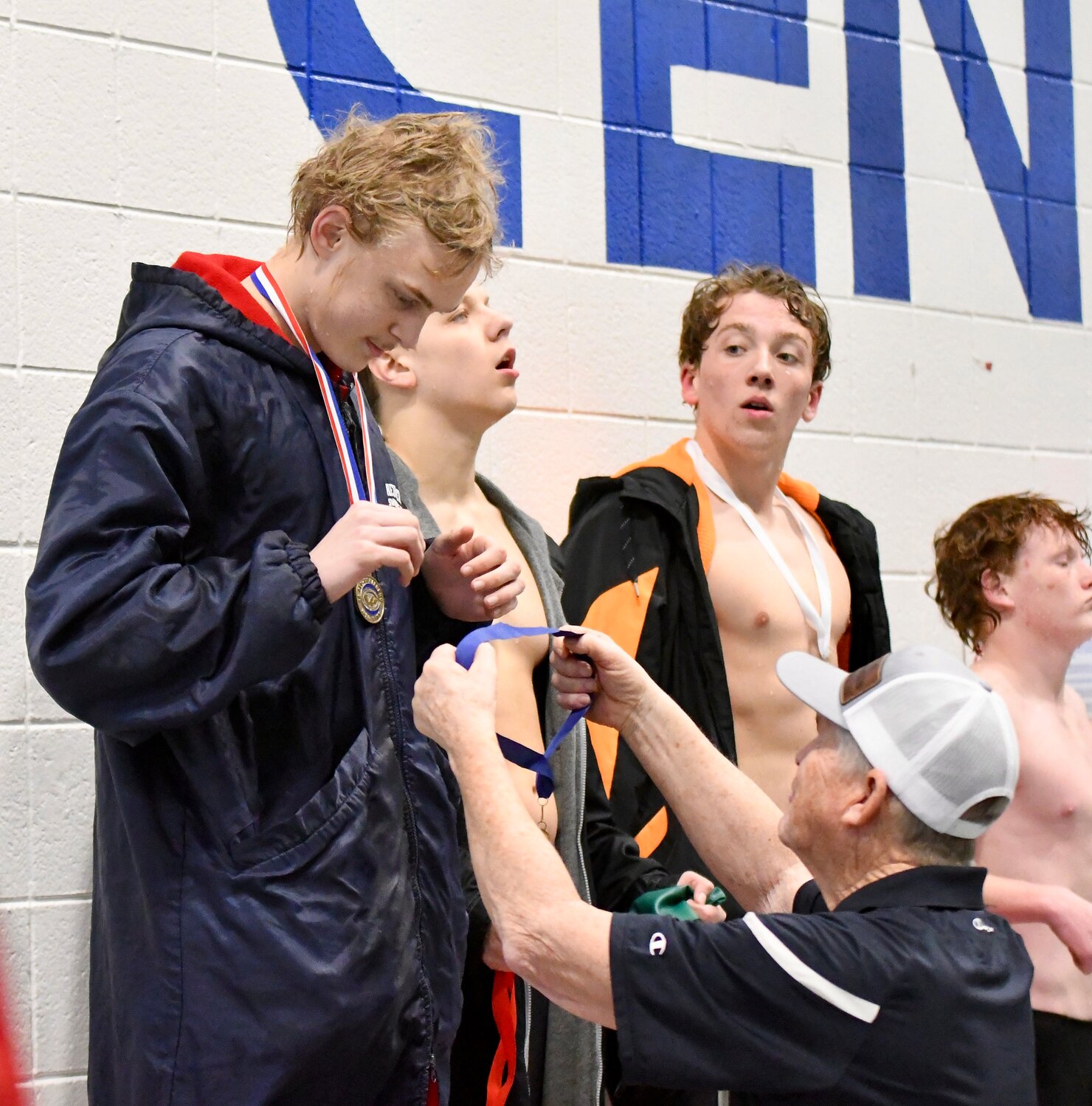 Red Devil swimmer Jacob Olson accepts his medals for winning the 500 freestyle at Saturday’s 4A West Conference Championship from Evanston head coach Jim Levine. Olson set a new conference record in the event, with a time of 5:13.16.