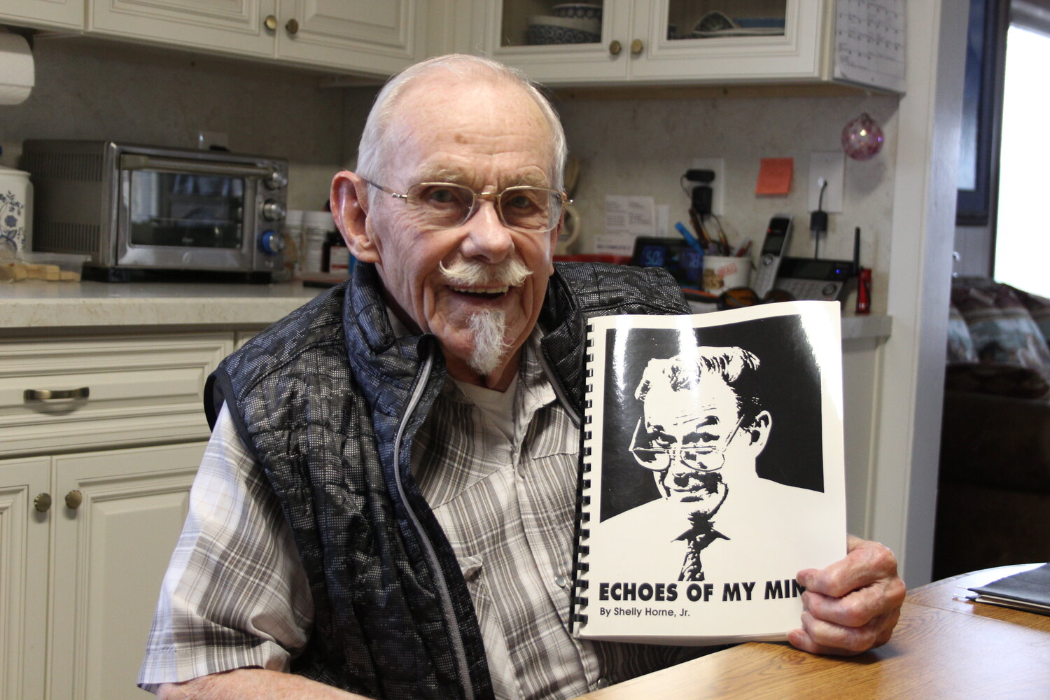 Shelly Horne displays his book of humorous articles he wrote years ago for the Uinta County Herald.