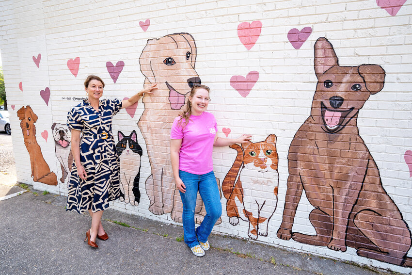 Sarah Lyles, Executive Director of PalmettoPride and Em Bender, mural artist, pose with the new mural.