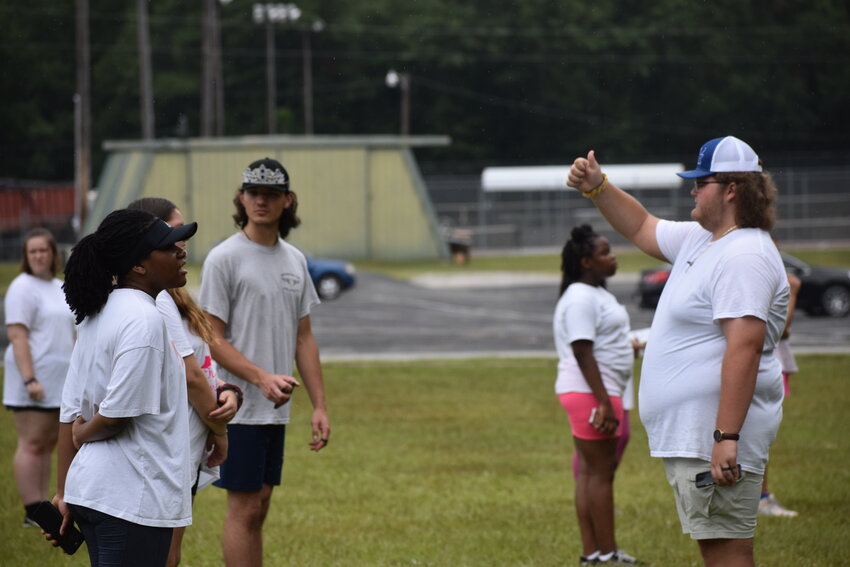 Seth Dorn, co-drum major, gives a thumbs up to a bandmate after helping them find their position on the field.