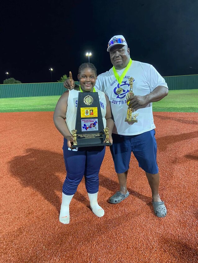 Genesis Walker, #16, and her father, Reggie, display the team’s trophy. Reggie was one of the coaches.