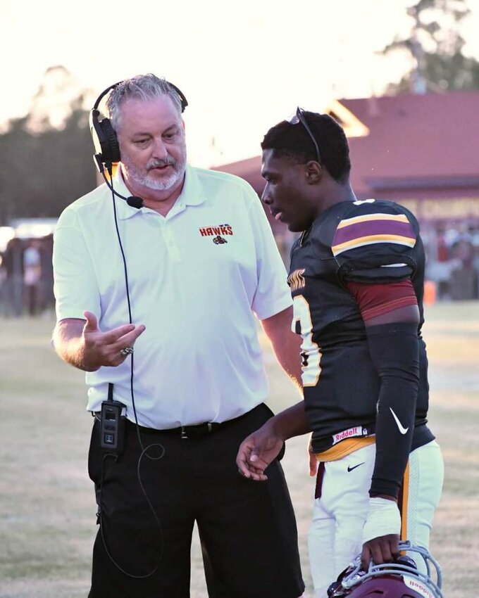 Hawks coach Kevin Jones talks with his QB Samari Williams about the next play. Williams threw a 26-yard TD to Messiah McFadden for the Hawks early in the 2nd half.