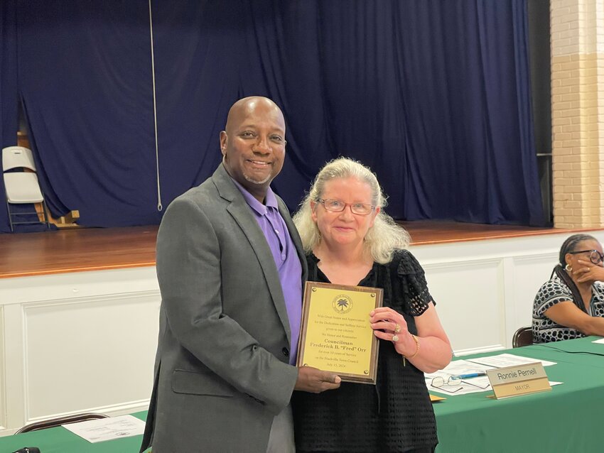 Kathy Orr is presented with a plaque honoring her late husband and former Blackville Town Councilman, Fred Orr. 
