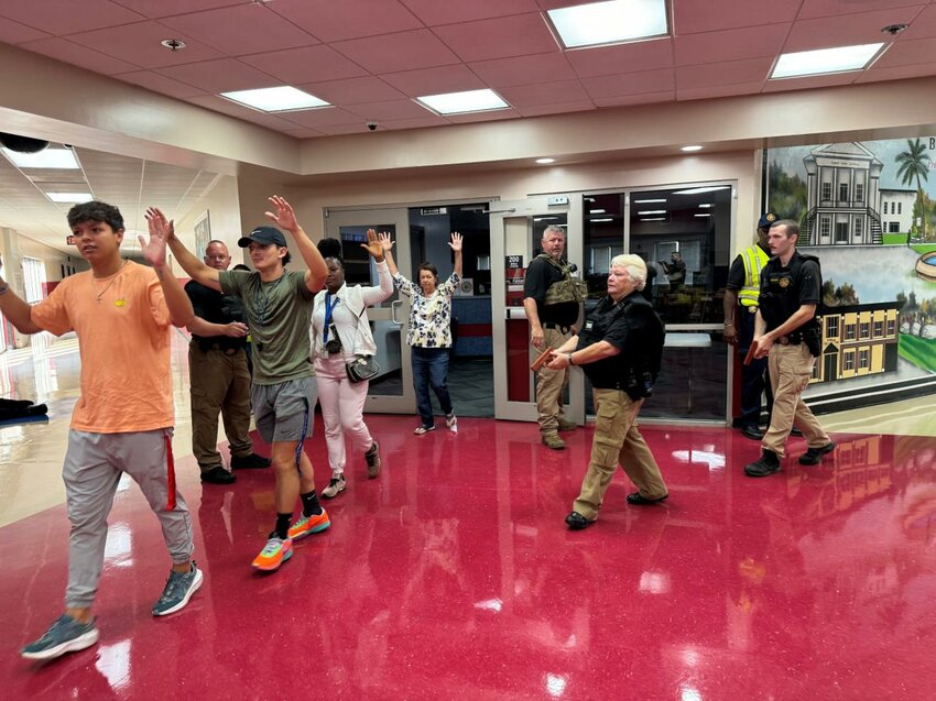 Barnwell County sheriff's deputies enter Barnwell Elementary School during an active shooter drill as Barnwell County School District employees, portraying victims, exit with their hands up.