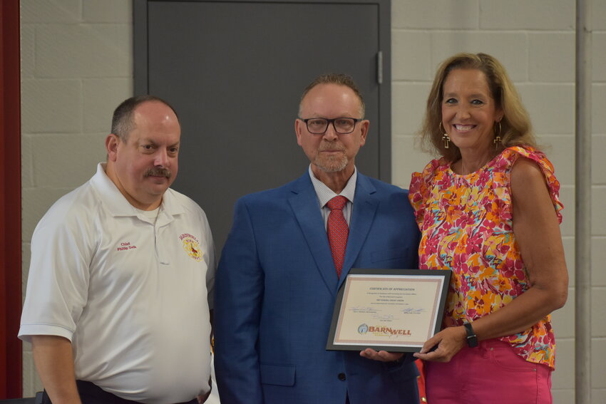 Angela Cotton (right) of SRP Federal Credit Union accepts a plaque honoring their part in making this project come to life. Cotton is pictured with Mayor Ron Still (middle) and Chief Phillip Delk (left). 