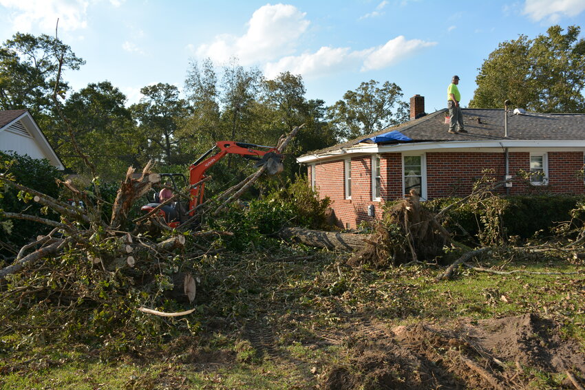 S.C. Baptist Disaster Relief crews work to cut trees that fell on this home on Winton Street in Barnwell and place a tarp on a damaged part of the home's roof following Hurricane Helene.